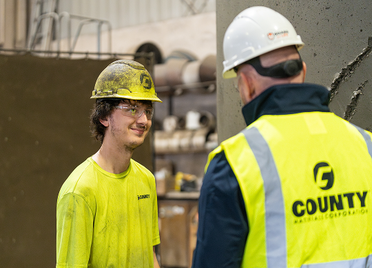 County Materials team member mentoring a young worker at a concrete manufacturing plant, representing student career opportunities.